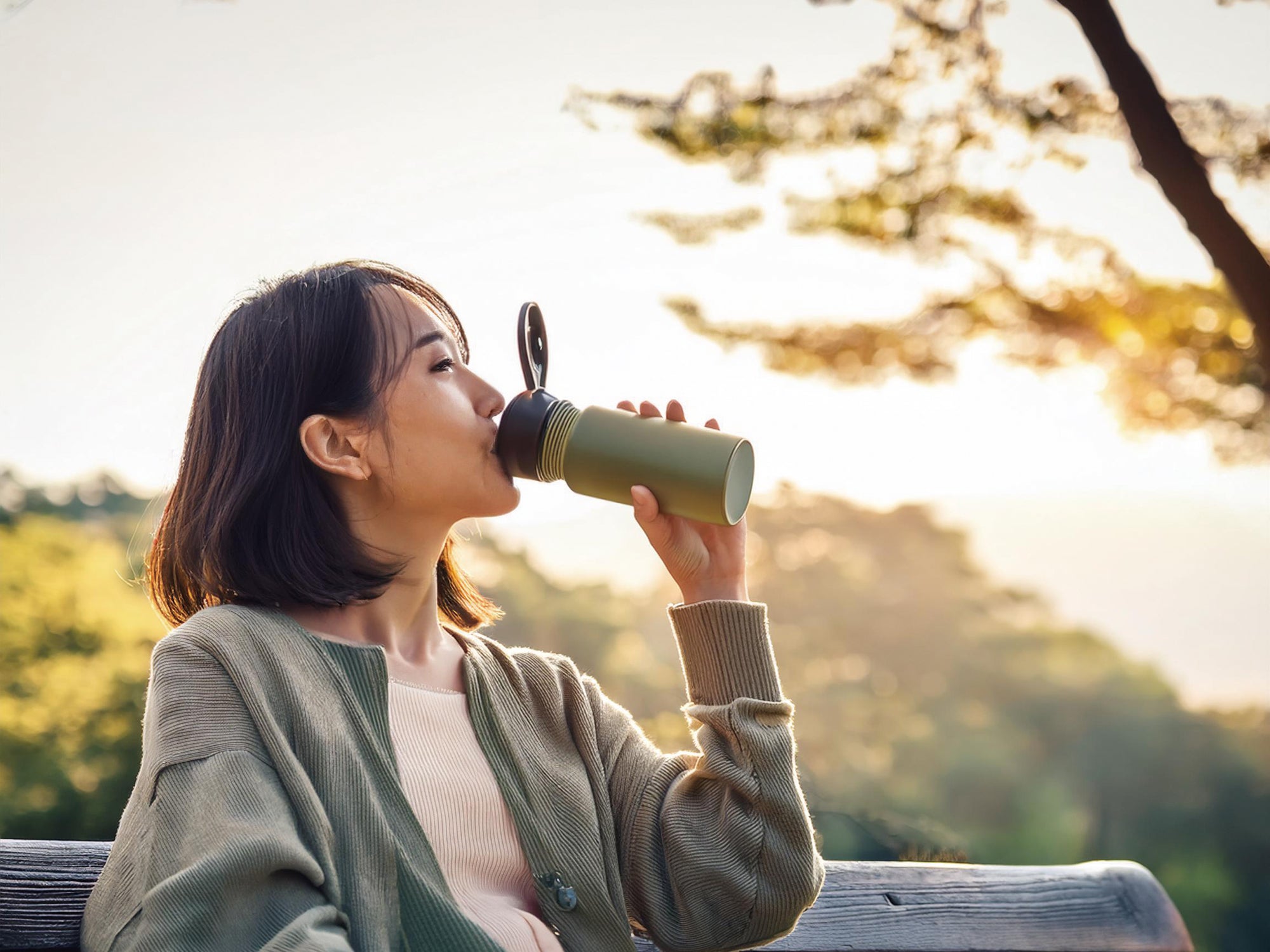 水筒のお茶を飲んでいる女性